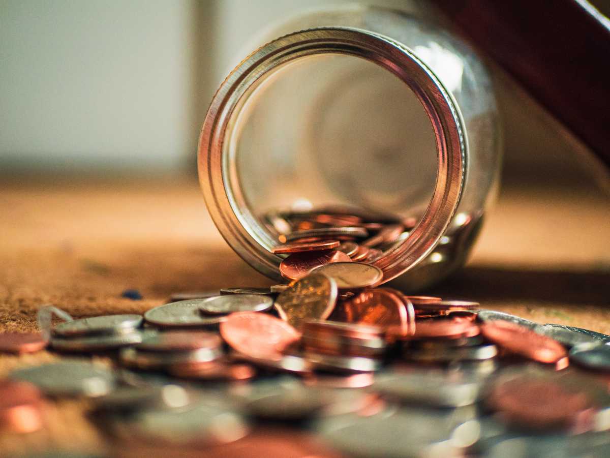 Jar of coins spilling out onto a surface